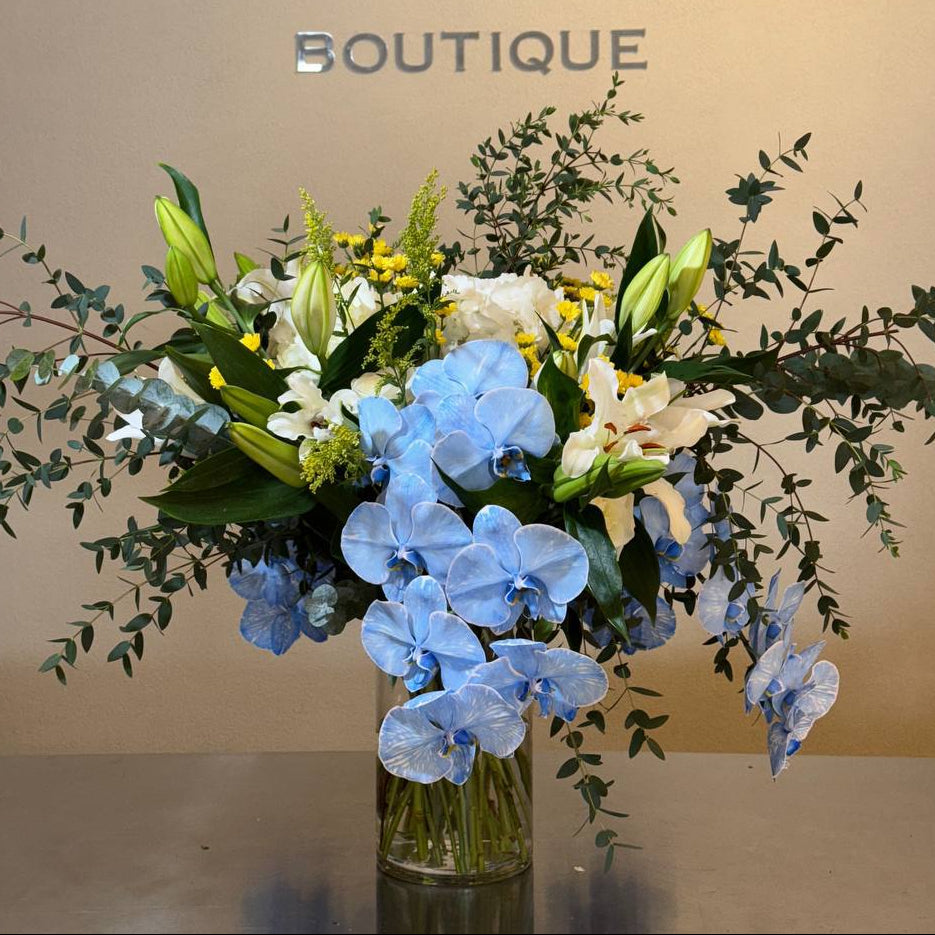 Get well soon flower arrangement with blue orchids, white lilies and eucalyptus in a tall glass vase – Vanda Flower Boutique
