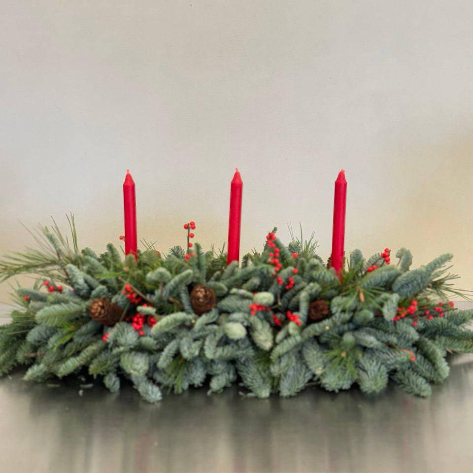 Fresh Christmas evergreen centerpiece with red candles, berries, and pinecones.
100 x 60 cm