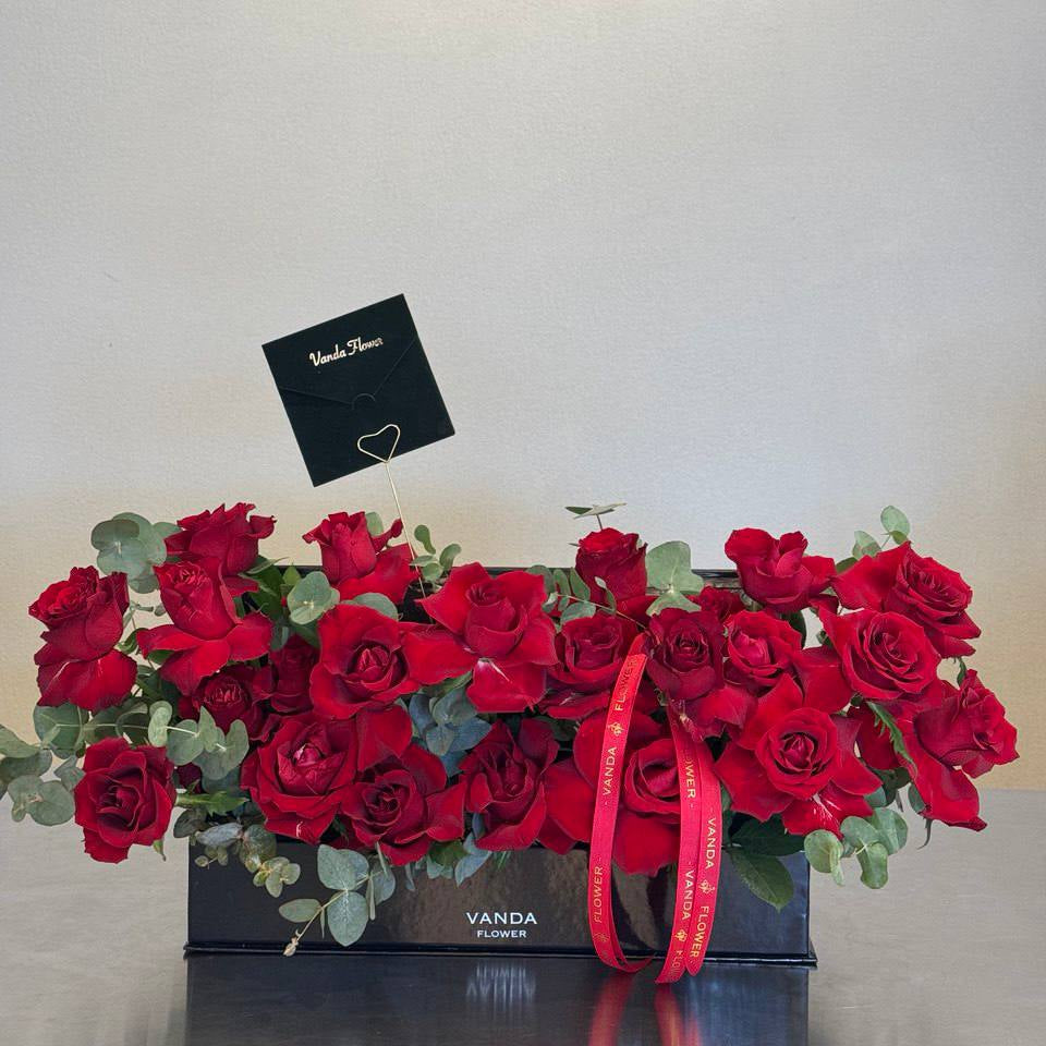  Large rectangular black flower box filled with premium red roses and eucalyptus, ribbon and card holder